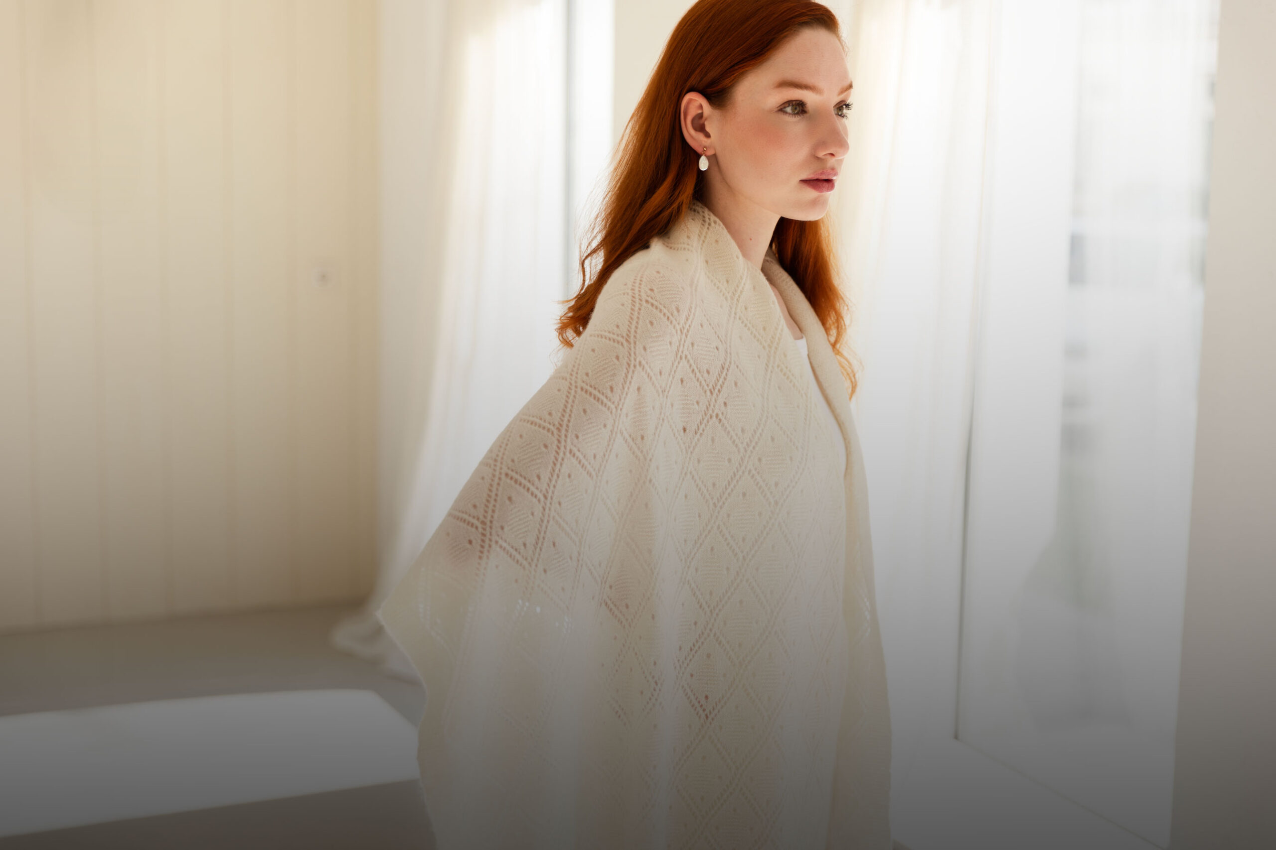 Woman wearing a soft lace cashmere scarf in white